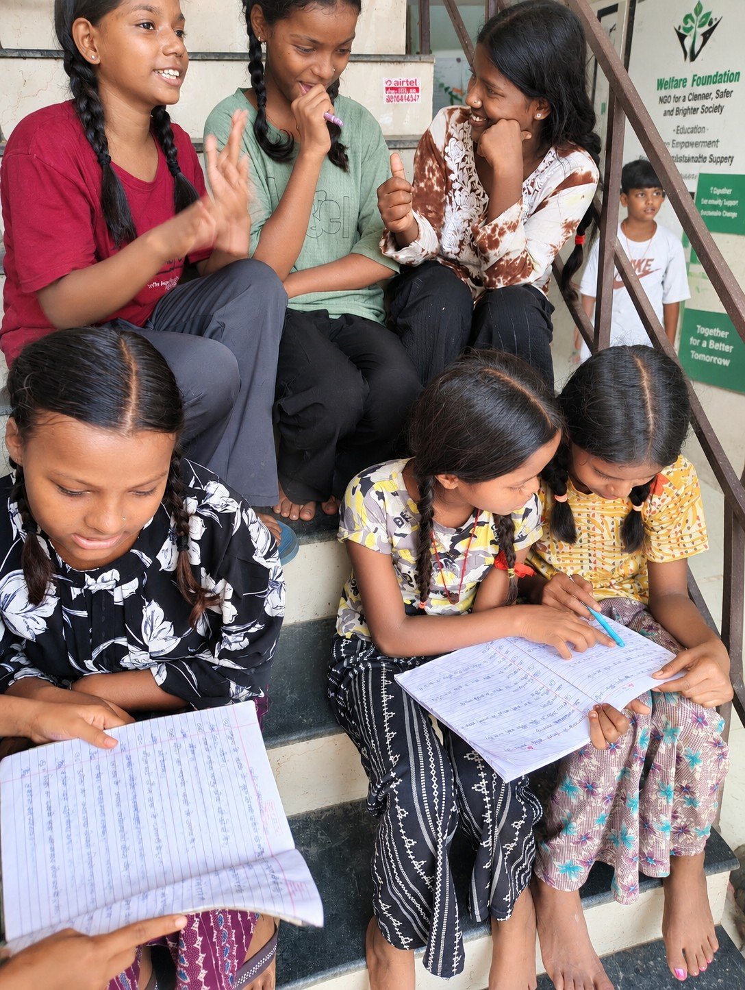 Children studying together outside centre with WWF banner